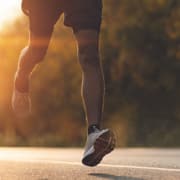 Läufer auf Straße mit Sportschuhen und passender Einlagenversorgung