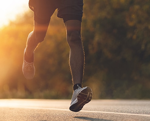 Läufer auf Straße mit Sportschuhen und passender Einlagenversorgung